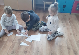 Ala, Leoś i Nikola układają puzzle.